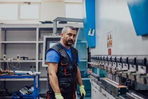 A smart factory worker or engineer makes machines in a production workshop. The concept of industry and engineering. Selective focus photo