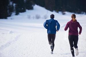 pareja trotando afuera en la nieve foto