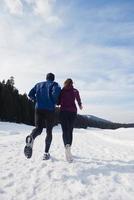 pareja trotando afuera en la nieve foto