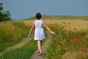 young woman in wheat field at summer photo