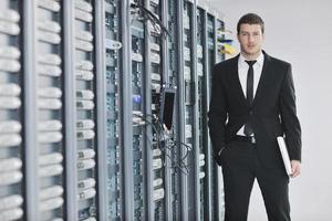 businessman with laptop in network server room photo