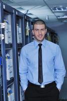 young it engineer in datacenter server room photo