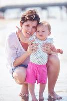 mamá y bebé en la playa se divierten foto