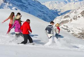 los amigos se divierten en invierno con nieve fresca foto