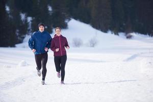 pareja trotando afuera en la nieve foto