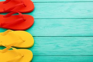Colorful flip flops on blue wooden background with copy space. Top view photo