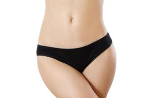 Healthy nutrition and belly health concept. Close up of woman flat stomach. Black Blank Template female panties with copy space and mock up. Front view. Cropped image, female bodycare isolated. photo