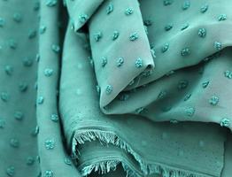 Detailed close up view on samples of cloth and fabrics in different colors found at a fabrics market photo