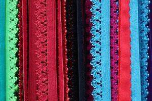 Detailed close up view on samples of cloth and fabrics in different colors found at a fabrics market photo