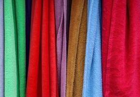 Detailed close up view on samples of cloth and fabrics in different colors found at a fabrics market photo