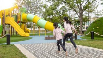 Asian little girl enjoys playing in a children playground, Outdoor portrait photo