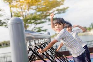 niños pequeños escalando en el patio de la escuela. foto