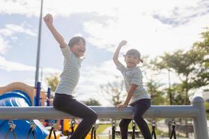 niños pequeños escalando en el patio de la escuela. foto