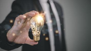 Businessman holding a bright light bulb. Concept of Ideas for presenting new ideas Great inspiration and innovation new beginning. photo