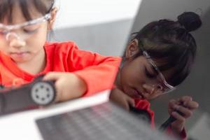 Asia students learn at home in coding robot cars and electronic board cables in STEM, STEAM, mathematics engineering science technology computer code in robotics for kids concept. photo