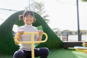 Kids playing at the see-saw in the playground photo