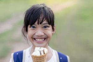 retrato de una linda chica con helado en un paseo por el parque. niño al aire libre foto