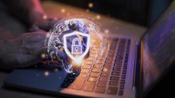 Cyber Security Internet And Networking Concept. Businessman Hand Working With laptop computer and virtual Screen Padlock Icon. Digital crime by an anonymous hacker, data protection. photo