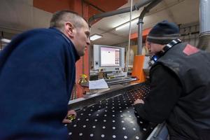 carpinteros calculando y programando una máquina de trabajo de madera cnc foto