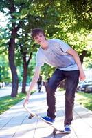 Skateboard jumping on sidewalk photo