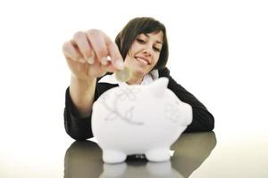 business woman putting coins money in piggy bank photo