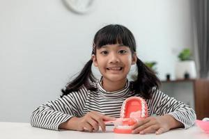 un niño pequeño juega con mandíbulas artificiales. odontologia infantil. foto