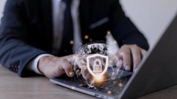 Cyber Security Internet And Networking Concept. Businessman Hand Working With laptop computer and virtual Screen Padlock Icon. Digital crime by an anonymous hacker, data protection. photo