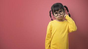 funny child girl wearing glasses on a colored background photo