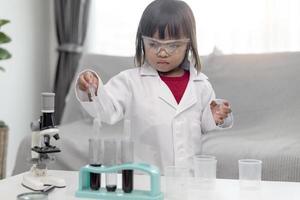 little girl scientist enjoy and excite to examine the color chemical in laboratory by using dropper with day light. Concept of good practice and education of science for children support. photo