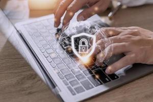 Cyber Security Internet And Networking Concept. Businessman Hand Working With laptop computer and virtual Screen Padlock Icon. Digital crime by an anonymous hacker, data protection. photo