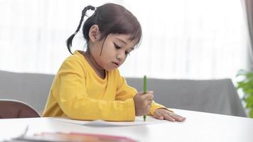 Asian Little kid doing homework at home. photo