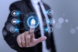 Cybersecurity and privacy concepts to protect data. Lock icon and internet network security technology. Businessman protecting personal data on smart phone with virtual screen interfaces. photo