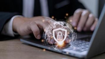 Cyber Security Internet And Networking Concept. Businessman Hand Working With laptop computer and virtual Screen Padlock Icon. Digital crime by an anonymous hacker, data protection. photo