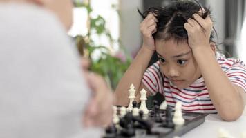 Little boy and little girl are playing chess at home.Children playing chess photo