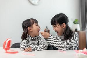 Cute Asian child playing with doctor dentist toy set, child shows how to clean and care for teeth. Dentistry and medicine, photo