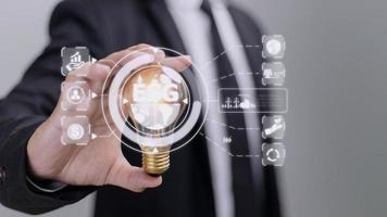 Hand holding light bulb with ESG icon concept for environmental, social, and governance in sustainable and ethical business on the Network connection on a green background. photo