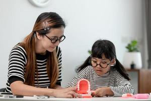 mother teaching daughter child teeth brushing at home photo