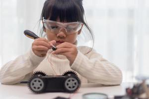 Asian students learn at home in coding robot cars and electronic board cables in STEM, STEAM, mathematics engineering science technology computer code in robotics for kids concept. photo