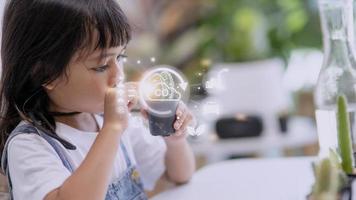 Little girl watching a plant. Environmental technology concept. Sustainable development goals. SDGs. photo