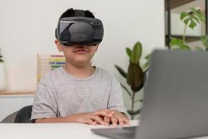 Asian Little boy with VR glasses studying sciences at home,curious student wears a virtual reality headset to study science home online study futuristic lifestyle learning photo