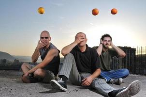 three man outdoor play with orange fruit photo