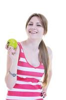 una joven feliz come manzana verde aislada en blanco foto