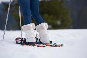 pareja divirtiéndose y caminando con raquetas de nieve foto