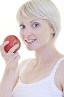 una joven feliz come manzana verde aislada en blanco foto