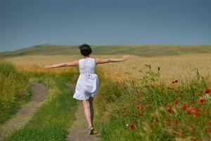 young woman in wheat field at summer photo