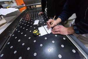 carpenters calculating and programming a cnc wood working machine photo