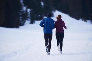pareja trotando afuera en la nieve foto