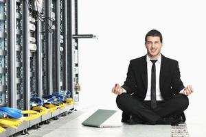 hombre de negocios practica yoga en la sala de servidores de red foto