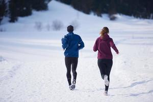 pareja trotando afuera en la nieve foto