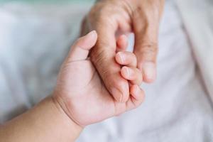 Close up baby hand on mother's hands photo